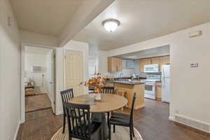 Dining room with dark wood-style flooring and a wall unit AC