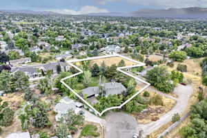 Aerial view of residential area with property parcel outlined and mountains