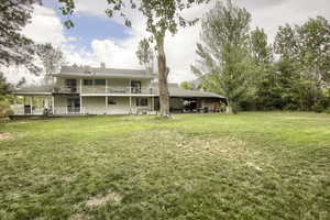 Rear view of property with a yard, a deck, and a chimney