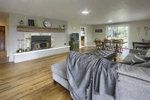 Living area featuring wood finished floors and a glass covered fireplace