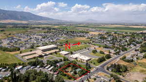 Aerial view of residential area with property parcel outlined and mountains