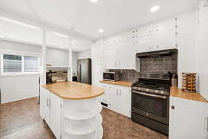 Kitchen featuring open shelves, backsplash, appliances with stainless steel finishes, light countertops, and white cabinetry