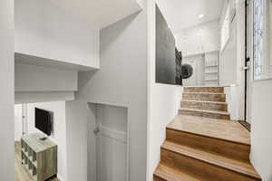 Staircase with estacked washer and dryer and recessed lighting