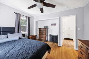 Bedroom with light wood finished floors, a textured ceiling, and a ceiling fan
