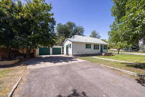 View of front of property with a metal roof, an outbuilding, and a detached garage