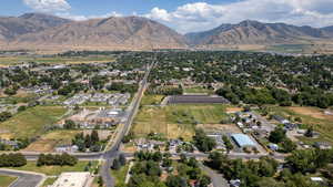 Aerial view of property and surrounding area featuring a mountainous background and nearby suburban area