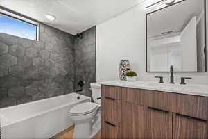 Full bath with vanity, bathtub / shower combination, and a textured ceiling