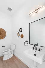 Bathroom with wood finished floors and toilet