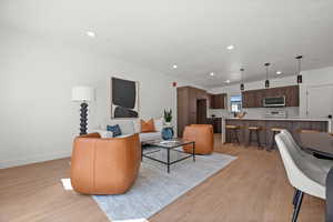 Living room featuring light wood finished floors and recessed lighting
