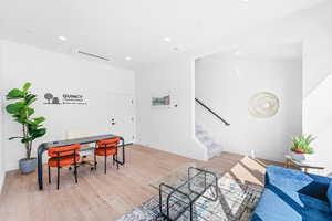 Living room with recessed lighting, light wood-style floors, stairway, and a desk