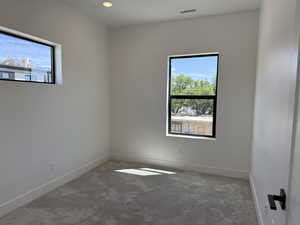Carpeted empty room with baseboards and recessed lighting