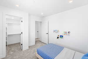 Carpeted bedroom featuring a spacious closet and recessed lighting