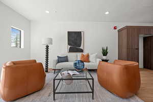 Living area with light wood-style floors and recessed lighting