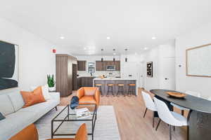 Living room with light wood finished floors and recessed lighting