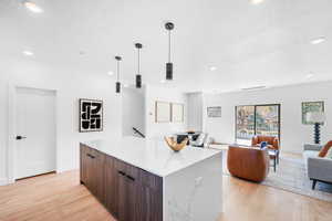 Kitchen featuring a center island, light wood-type flooring, modern cabinets, a textured ceiling, and recessed lighting