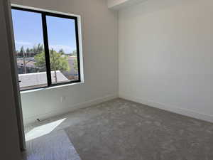 Carpeted empty room featuring baseboards