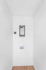 Washroom featuring hookup for an electric dryer, hookup for a washing machine, and light wood-style floors