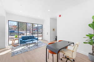 Living room with wood finished floors, an office area, and recessed lighting
