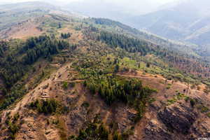 Aerial view of property and surrounding area featuring a mountainous background