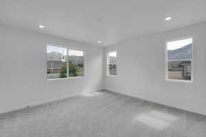 Carpeted empty room featuring a mountain view and recessed lighting
