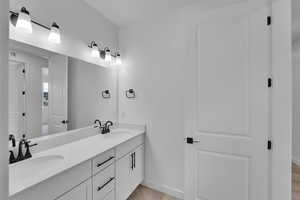 Full bathroom featuring double vanity and wood finished floors