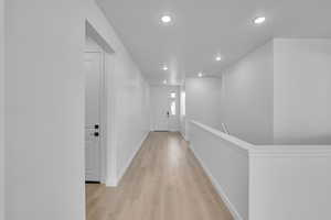 Hall featuring light wood-style flooring and recessed lighting