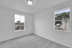 Carpeted empty room featuring baseboards