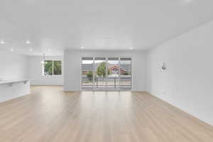 Unfurnished living room with light wood-style floors, recessed lighting, and a chandelier