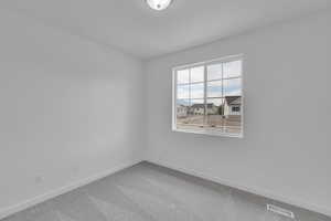 Carpeted spare room with baseboards