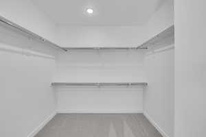 Walk in closet with light carpet