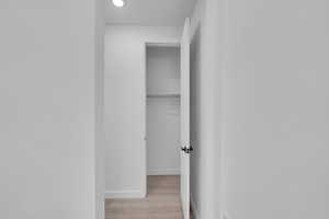 Hallway with baseboards and wood finished floors