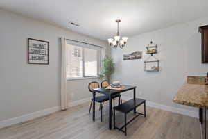 Dining space featuring light wood-style flooring and a chandelier
