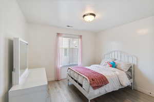 Bedroom featuring light wood finished floors and baseboards