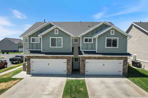 Craftsman-style home featuring board and batten siding, roof with shingles, and stone siding