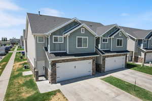 Craftsman-style home featuring board and batten siding, roof with shingles, and stone siding