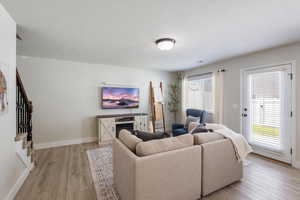 Living area with light wood finished floors and stairway