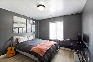 Bedroom featuring wood finished floors and baseboards
