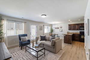 Living room with light wood-style flooring, a chandelier, recessed lighting, and a textured ceiling