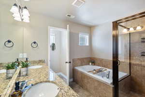 Full bath featuring a shower stall, a bath, and double vanity