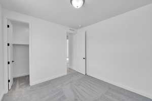 Unfurnished bedroom with carpet and a walk in closet