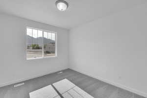 Carpeted spare room featuring baseboards