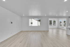 Unfurnished living room featuring plenty of natural light, recessed lighting, light wood-type flooring, a chandelier, and a textured ceiling