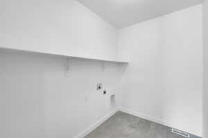 Washroom featuring electric dryer hookup, washer hookup, and light tile patterned floors