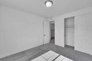 Unfurnished bedroom featuring carpet and a closet