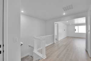 Unfurnished room with wood finished floors and recessed lighting
