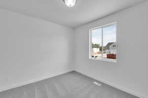 Empty room featuring carpet and a textured ceiling