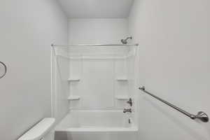 Bathroom featuring toilet and washtub / shower combination