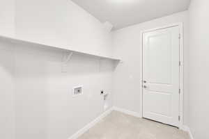 Laundry room with hookup for a washing machine, hookup for an electric dryer, and light tile patterned floors