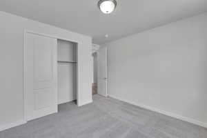 Unfurnished bedroom featuring carpet and a closet
