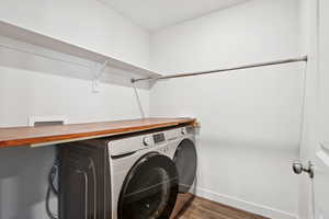 Laundry room featuring independent washer and dryer and wood finished floors